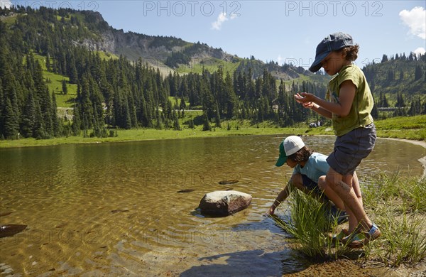 Mixed race children playing near remote lake