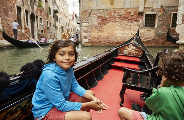 Boy sitting in gondola on Venice canal