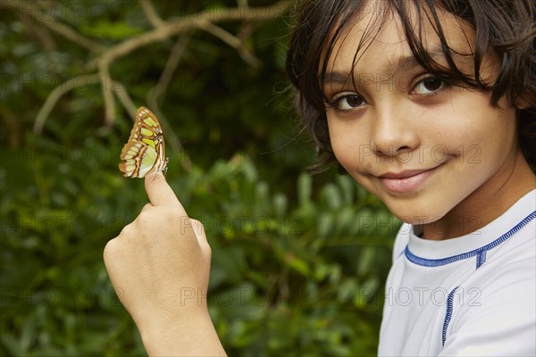 Mixed race boy holding butterfly