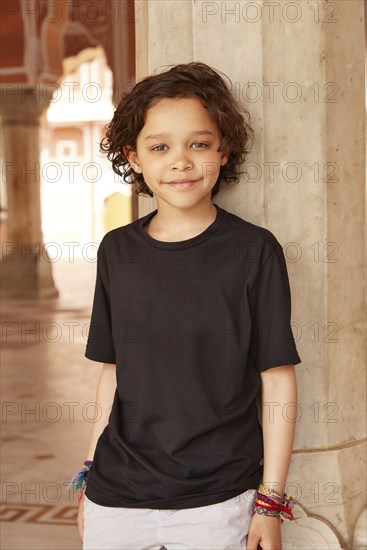 Mixed Race boy leaning on pillar