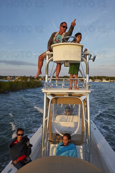 Man on boat tower pointing with son