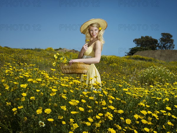 Caucasian woman picking wildflowers in field