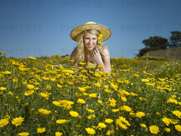 Caucasian woman picking wildflowers in field