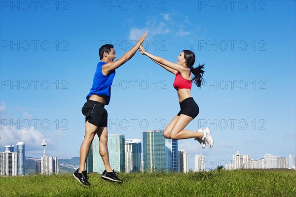 Couple high-fiving in field