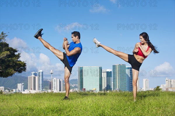 Couple exercising together in field