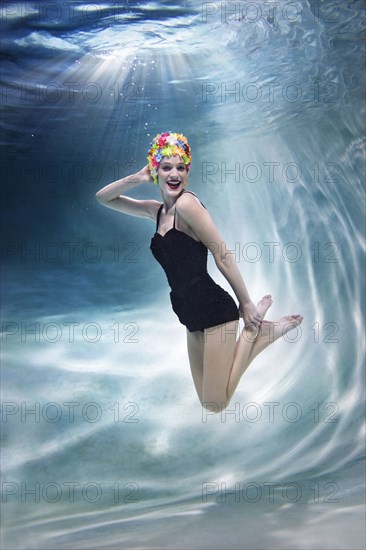 Mixed race woman swimming underwater