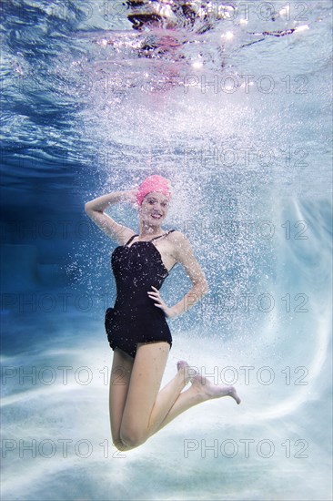 Mixed race woman swimming underwater