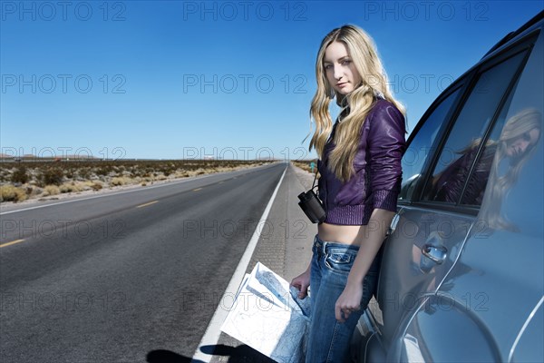 Caucasian woman reading map at roadside
