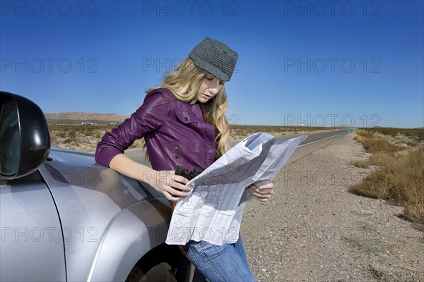 Caucasian woman reading map at roadside