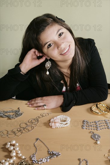 Hispanic teenager putting on jewelry