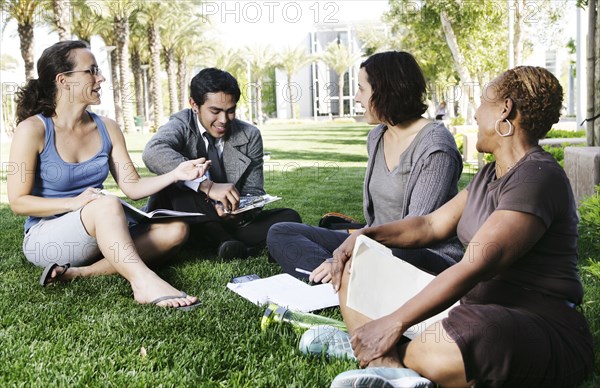 Adult students studying together in park