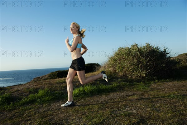 Caucasian woman running near ocean