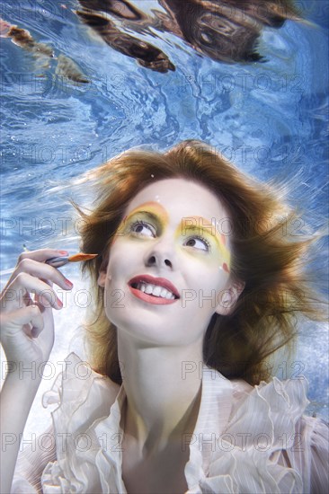 Caucasian putting makeup on under water