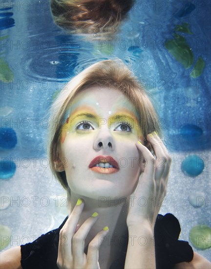 Caucasian woman with makeup on under water