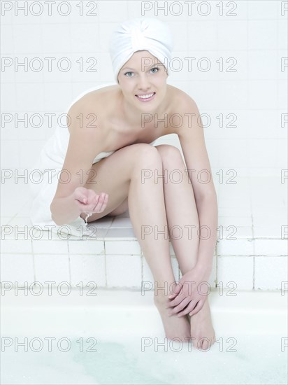 Caucasian woman dipping toe in water