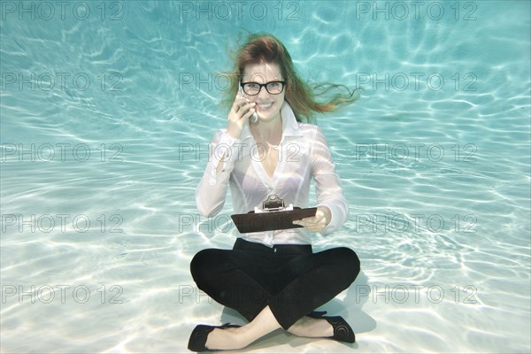 Caucasian businesswoman sitting underwater