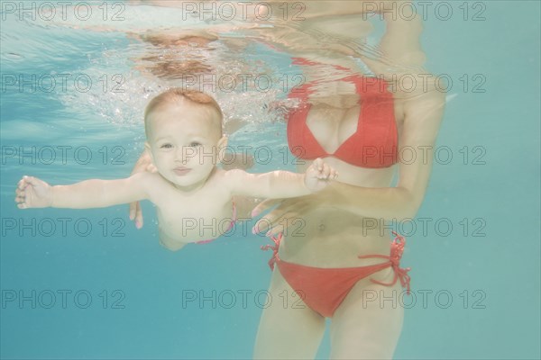 Caucasian baby swimming underwater