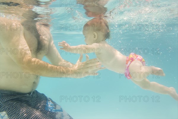 Caucasian baby swimming underwater