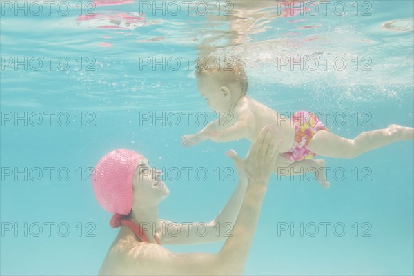 Caucasian baby swimming underwater