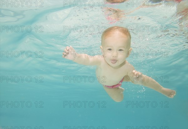 Caucasian baby swimming underwater