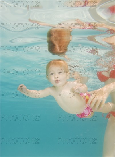 Caucasian baby swimming underwater