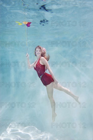 Caucasian woman with balloons underwater