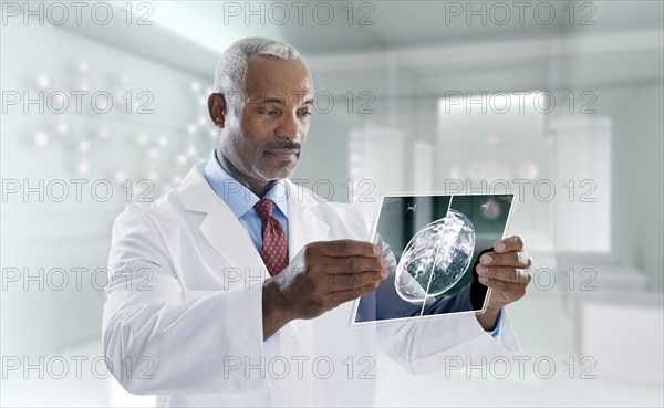 Mixed race doctor using digital tablet