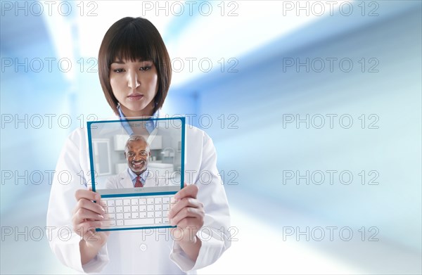 Mixed race doctor using digital tablet