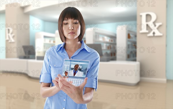 Mixed race woman using digital tablet in pharmacy