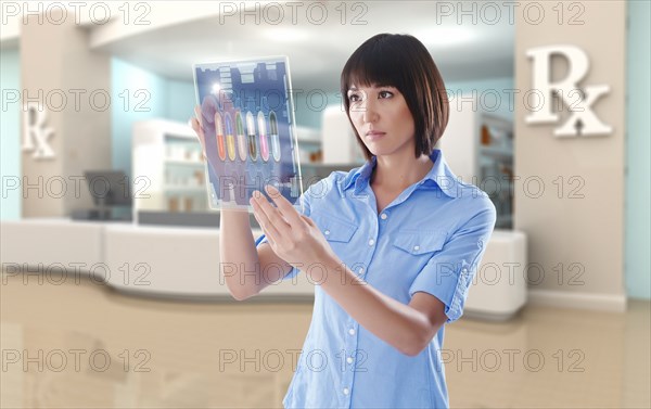 Mixed race woman using digital tablet in pharmacy