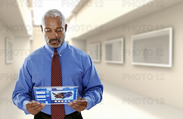 Black businessman using digital tablet in office