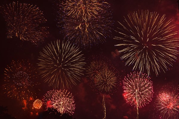 Fireworks exploding in red sky