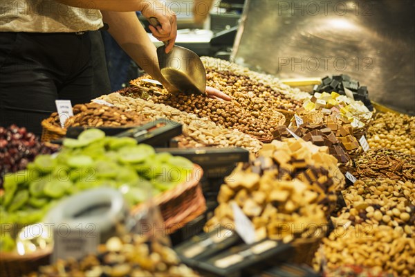 Person scooping nuts at market