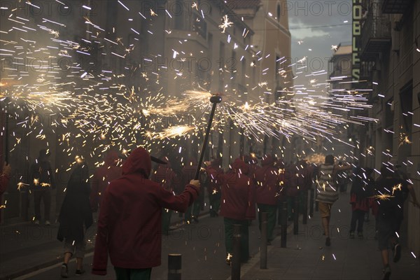 Crowd carrying torches with sparks in parade at night