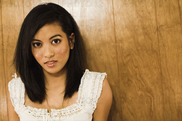 Asian woman leaning against wall