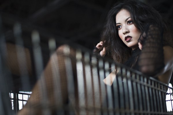 Asian woman sitting in shopping cart