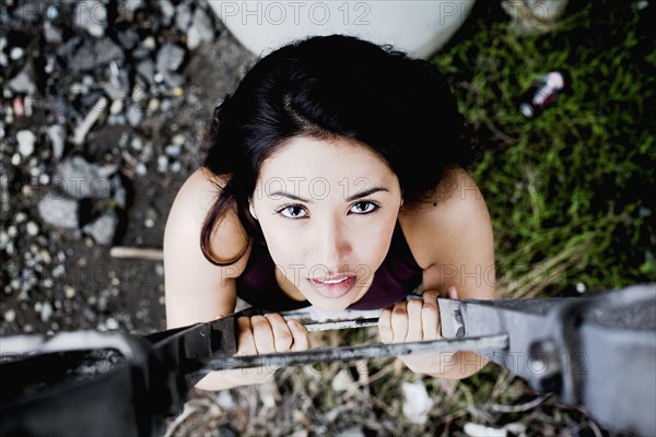 Middle Eastern woman climbing up ladder