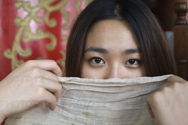 Chinese woman hiding behind scarf