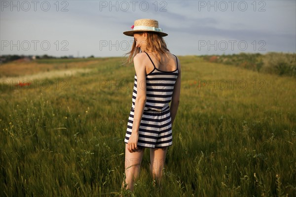 Caucasian woman standing in field of tall grass