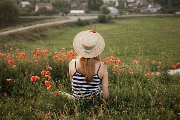 Caucasian woman sitting in wildflowers