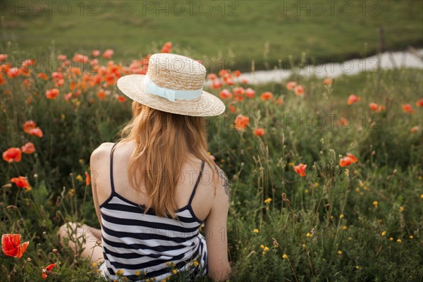 Caucasian woman sitting in wildflowers