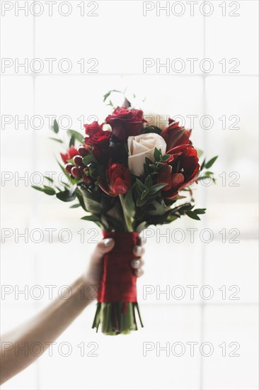 Hand of Caucasian woman holding bouquet of flowers