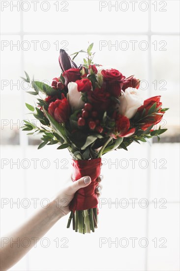 Hand of Caucasian woman holding bouquet of flowers