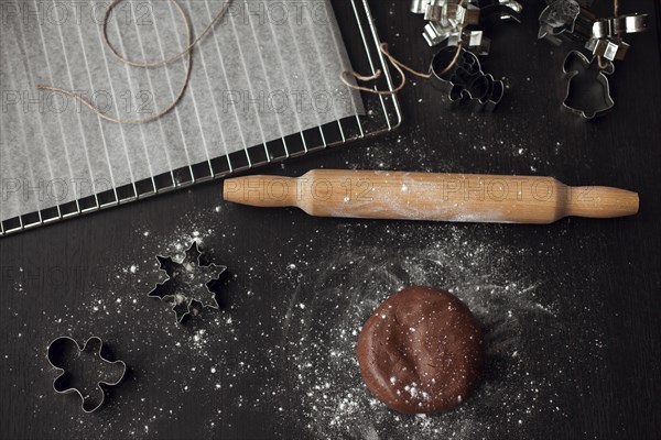 Pastry cutters and gingerbread dough near rolling pin