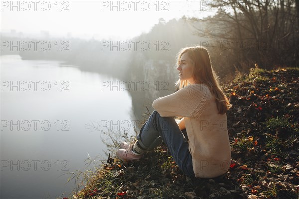 Caucasian woman sitting at the edge of reservoir