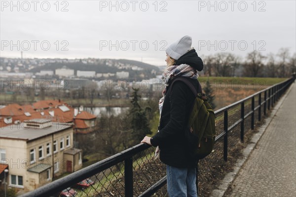 Caucasian woman wearing backpack admiring scenic view of city