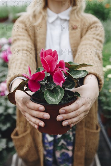 Caucasian girl holding flowers in pot