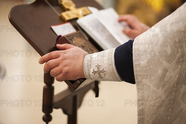 Hands of priest on pulpit