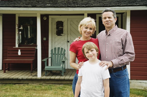 Portrait of family in front of house