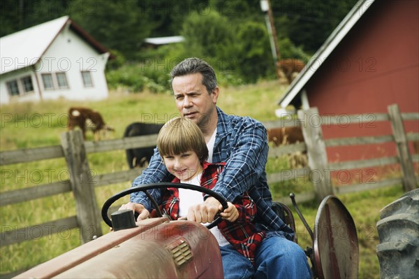 Father and son driving tractor